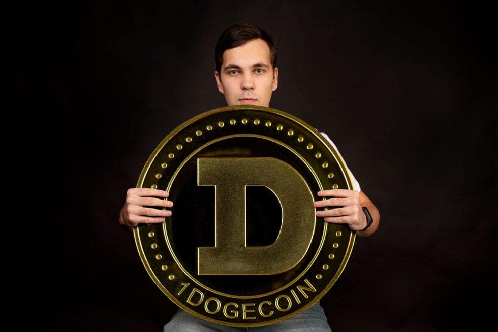 A Young Guy Holds A Symbol Of Dogecoin